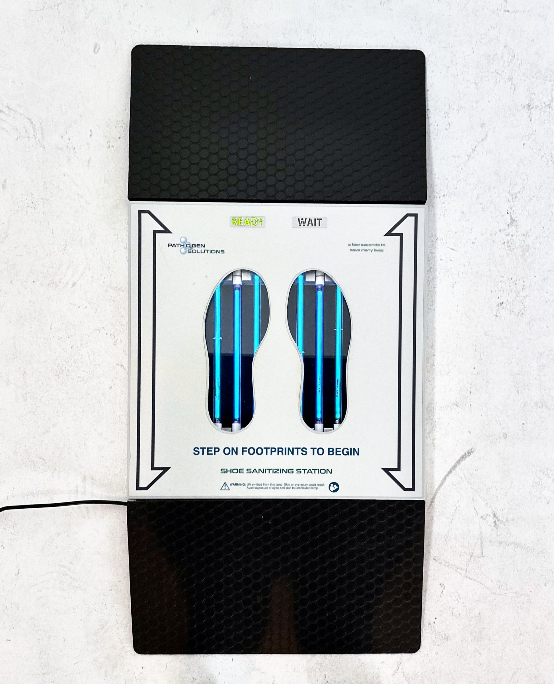 UVZone shoe sanitizing station seen from above with a ramp at each end and the READY indicator lit